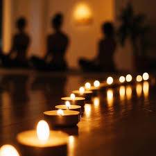 candles burning in a room where people are practicing yoga